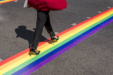 Legs of businesswoman crossing the street on LGBT stripes, London, UK - MAUF02955