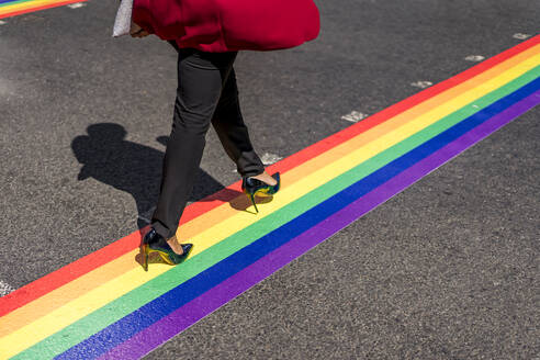 Beine einer Geschäftsfrau beim Überqueren der Straße auf LGBT-Streifen, London, UK - MAUF02955