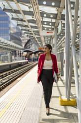 Businesswoman walking on platform, London, UK - MAUF02968