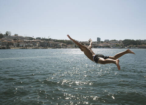Junger Mann springt ins Wasser, Porto, Portugal, lizenzfreies Stockfoto
