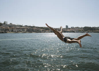 Young man jumping into the water, Porto, Portugal stock photo