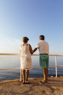 Rear view of senior couple at viewpoint at the coast, El Roc de Sant Gaieta, Spain - MOSF00001