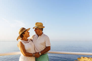 Senior couple embracing at viewpoint at the coast, El Roc de Sant Gaieta, Spain - MOSF00005