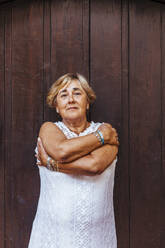 Porträt einer älteren Frau vor einer Holztür - MOSF00019