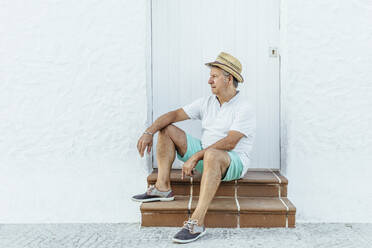 Älterer Tourist sitzt auf der Treppe in einem Dorf, El Roc de Sant Gaieta, Spanien - MOSF00025