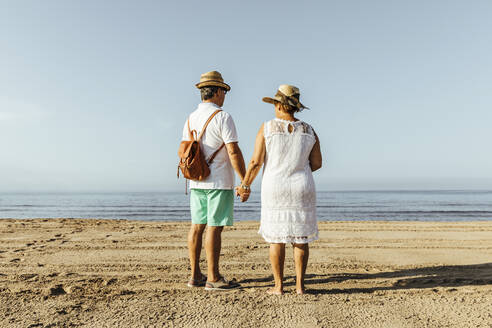 Rear view of senior couple on the beach, El Roc de Sant Gaieta, Spain - MOSF00029