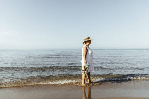 Senior woman wading in the sea, El Roc de Sant Gaieta, Spain - MOSF00031