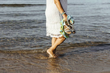 Close-up of senior woman wading in the sea, El Roc de Sant Gaieta, Spain - MOSF00032