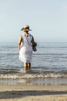 Senior woman wading in the sea, El Roc de Sant Gaieta, Spain - MOSF00033