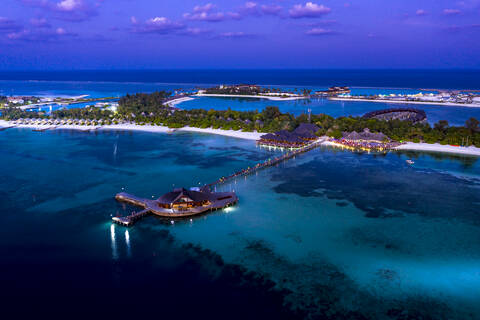 Malediven, Olhuveli, Luftaufnahme des Küstenurlaubsortes auf dem Süd Male Atoll in der Abenddämmerung, lizenzfreies Stockfoto