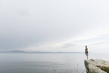 Woman standing on rock, looking at the sea - AHSF00872