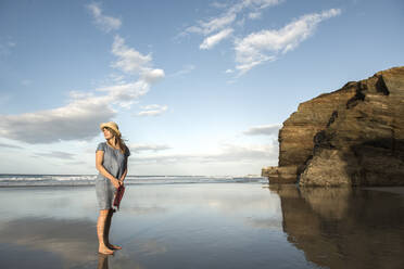 Woman standing on beach, looking at sea - AHSF00895