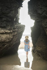 Frau stehend am Strand von Cathedrals mit Felsen, Rückansicht, Galicien, Spanien - AHSF00898