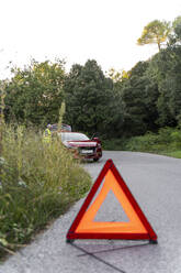 Warning triangle in front of a broken car on a country road - AFVF04050