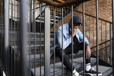 Portrait of man sitting on stairs - IGGF01360