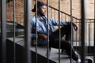 Man relaxing on stairs - IGGF01362