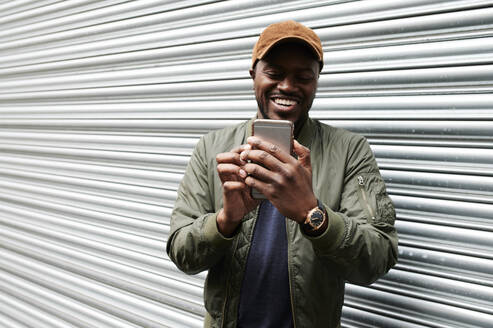 Porträt eines lachenden Mannes, der ein Selfie mit seinem Smartphone macht - IGGF01369