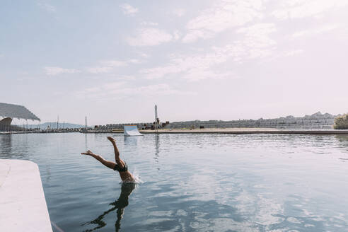 Young man jumping into water from a pier - MOSF00046