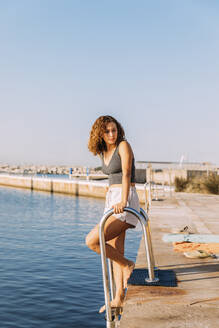 Young woman on a pier at swimming area - MOSF00049