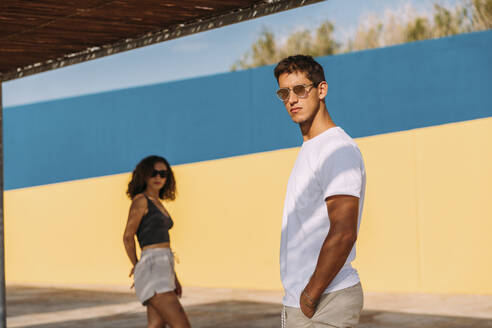 Cool young couple wearing sunglasses standing outdoors in summer - MOSF00066
