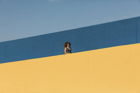 Young woman behind a yellow wall - MOSF00067