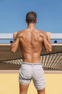 Rear view of athletic young man in shorts - MOSF00079