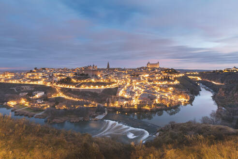 Spanien, Provinz Toledo, Toledo, Fluss Tejo und beleuchtete Stadt in der Morgendämmerung - WPEF02033