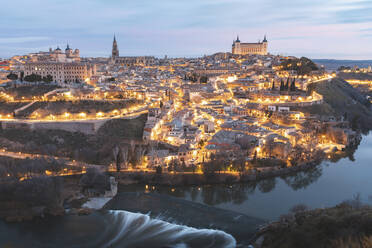 Spain, Province of Toledo, Toledo, Tagus river and illuminated city at dawn - WPEF02034