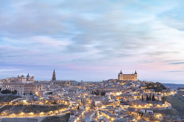 Spanien, Provinz Toledo, Toledo, Wolken über beleuchteter Stadt in der Morgendämmerung - WPEF02035