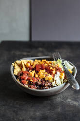 Bowl of nachos with, chili con carne, rice, lettuce, cheese and tomatoes - SBDF04069