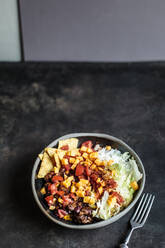 Bowl of nachos with, chili con carne, rice, lettuce, cheese and tomatoes - SBDF04070