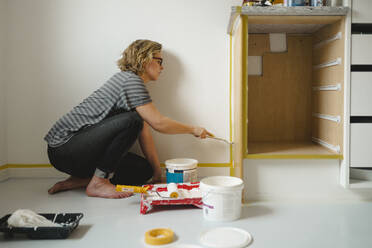 Woman painting cupboard - JOHF02731