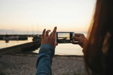 Frau beim Fotografieren des Sonnenuntergangs - JOHF02744