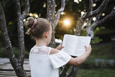 Girl reading in garden - JOHF02858