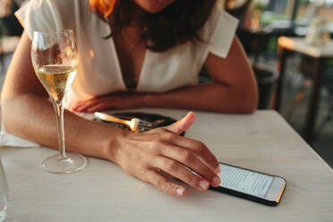 Frau im Restaurant, die ein Mobiltelefon benutzt - JOHF02958