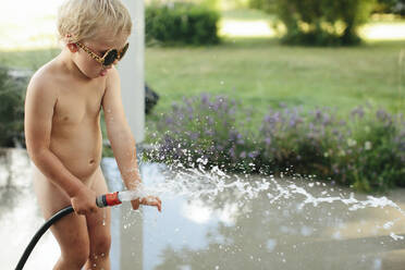 Girl playing with garden hose - JOHF03002