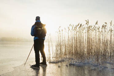 Mann beim Schlittschuhlaufen auf zugefrorenem See - JOHF03032
