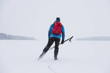 Mann beim Schlittschuhlaufen auf zugefrorenem See - JOHF03042