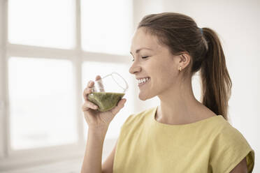 Smiling woman drinking smoothie - JOHF03049