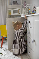 Girl looking into cupboard - JOHF03175
