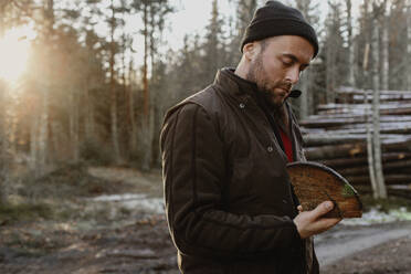 Man holding piece of log - JOHF03267