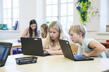 Mädchen benutzen Laptops in der Schule - JOHF03352