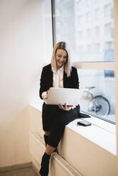 Businesswoman using laptop - JOHF03422