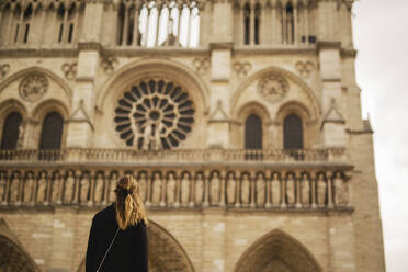 Frau betrachtet die Fassade von Notre Dame de Paris, Paris, Frankreich - JOHF03459