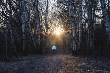 Woman walking through forest - JOHF03500
