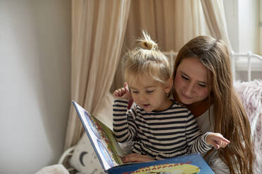 Mutter mit Tochter, die ein Buch liest - JOHF03564