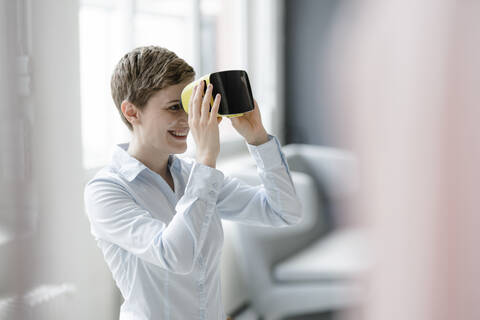 Lächelnde Frau mit VR-Brille im Büro, lizenzfreies Stockfoto