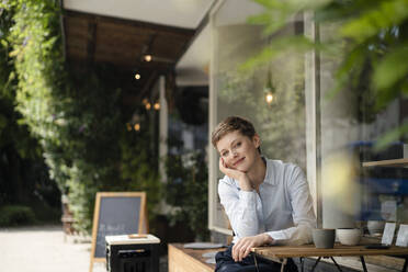 Portrait of smiling businesswoman at a cafe - KNSF06760