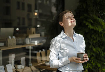 Entspannte Geschäftsfrau bei einem Kaffee in einem Cafe - KNSF06763