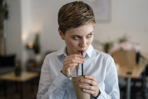 Geschäftsfrau in einem Café trinkt aus einem Becher - KNSF06782